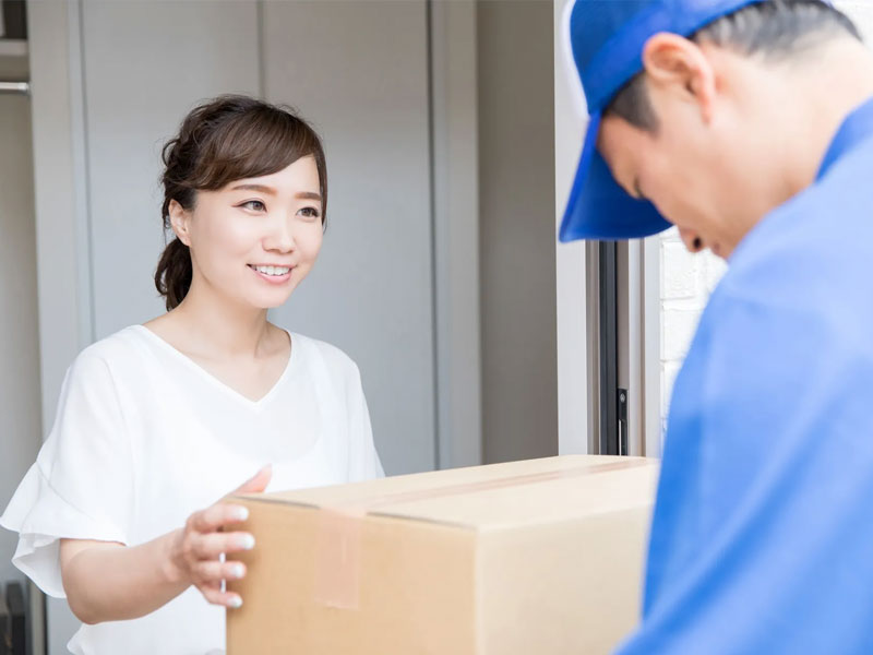 個人宅へ荷物を配達するドライバー